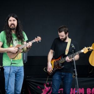 Mark Curtis playing ukulele and Elijah Maddern playing bass guitar at a JAM Band performance in Adelaide South Australia