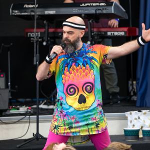 Nick Russell from JAM Band wearing colourful clothes and doing a power stance while singing at a performance in Adelaide South Australia