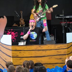 Nina Verlingieri singing and standing behind a viking ship at a JAM Band performance in Adelaide South Australia