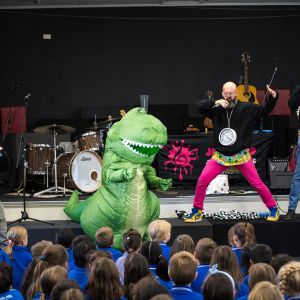 Jono Ruse and Nick Russell and Mark Curtis rapping next to a green dinosaur at a JAM Band performance in Adelaide South Australia